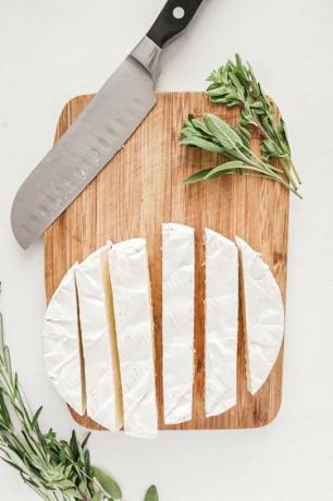 Brie fatiado em uma tábua de madeira