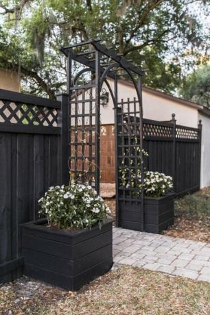 idea di decorazione della nonna costiera per patio con pergolato e composizioni floreali bianche