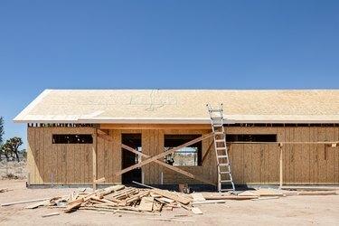 Construction de maison avec poutres et revêtement en bois dans le désert