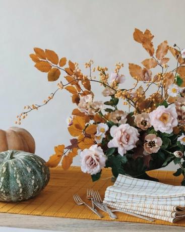 herfstkeuken decor met gele tafelloper met geel en roze bloemstuk op de top