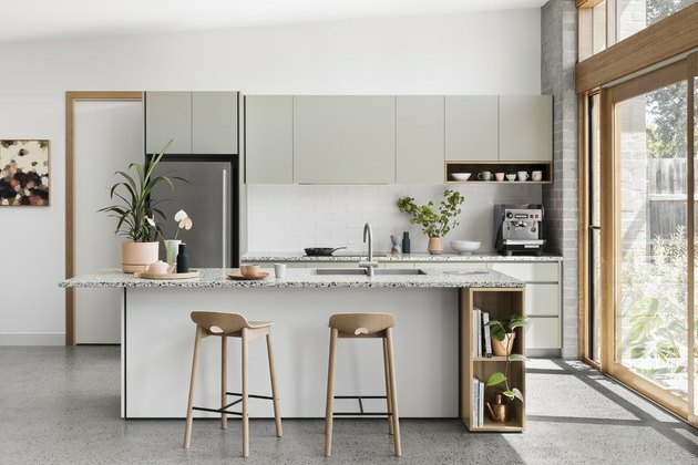 idea di isola cucina con piano in terrazzo e sgabelli in legno