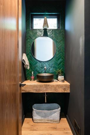 Idéia de banheiro de porão de azulejos verdes com um balcão de madeira e piso com pequena janela