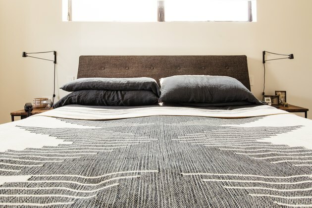 Letto con cuscino grigio e copriletto desert chic