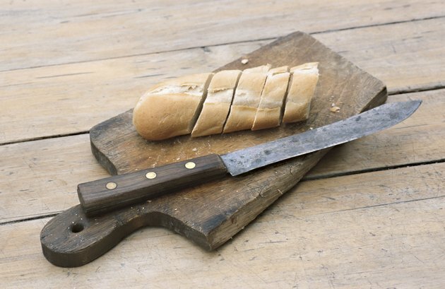 Tranches de pain au couteau sur une planche à découper