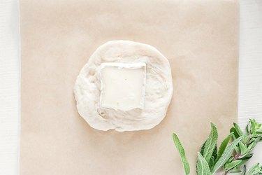Um pedaço de queijo brie em cima da massa de biscoito