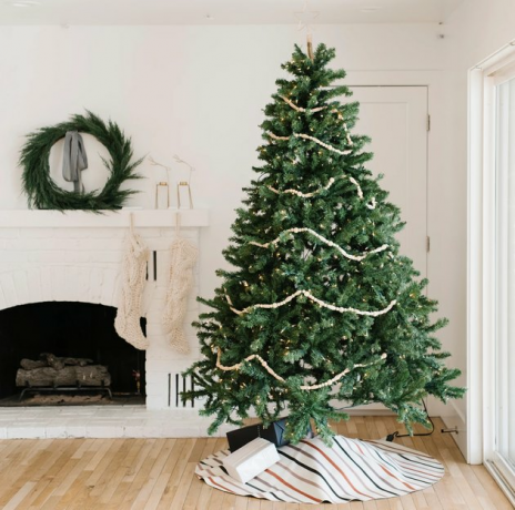 decoração de natal de casa de fazenda com saia de árvore na sala de estar branca de casa de fazenda