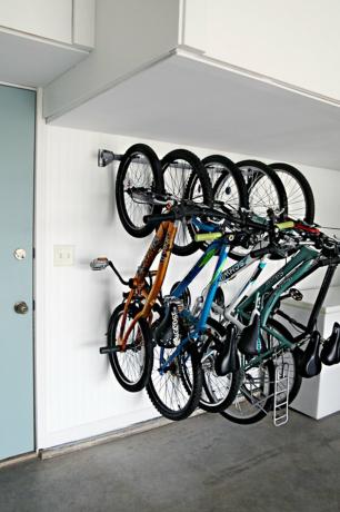 suporte para armazenamento de bicicletas na parede da garagem ao lado da porta azul