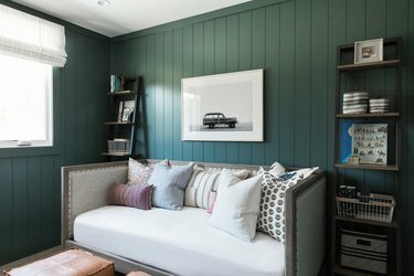 Sebuah kantor dengan sofa di mana trim hijau lumut memiliki warna yang sama dengan dindingnya.