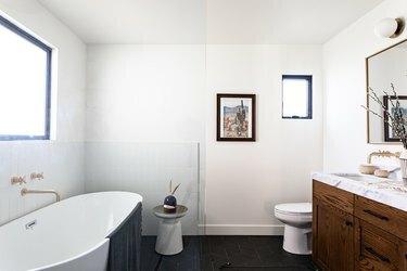 Łazienka z wolnostojącą wanną i drewnianą toaletką