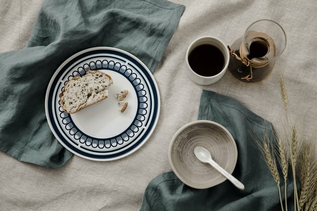 mesa de jantar com roupa de cama Cultiver e louça em cerâmica