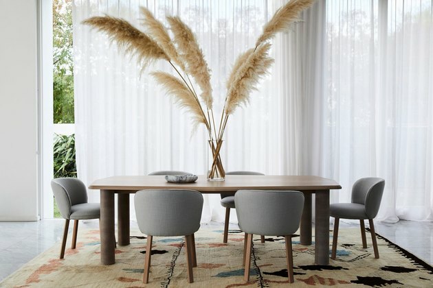 móveis ecológicos com sala de jantar moderna com mesa de madeira, cadeiras cinza e grande mesa central de grama de pampa