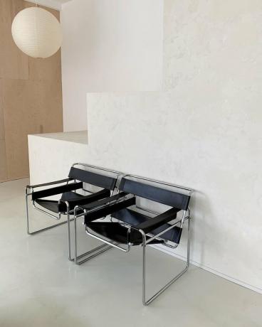 Quarto em estilo Bauhaus com duas cadeiras vintage Bauhaus pretas e lanterna de papel suspensa