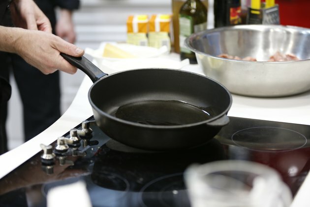 Serpenyőben növényi olajjal a konyhában. Növényi olaj egy serpenyőben. Melegítse elő az olajat