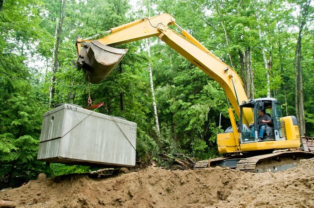 Installera septiktank med grävmaskin på byggarbetsplatsen