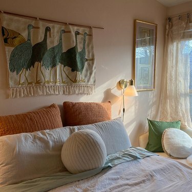 sypialnia z oszczędnymi poduszkami i wiszącym ptaszkiem