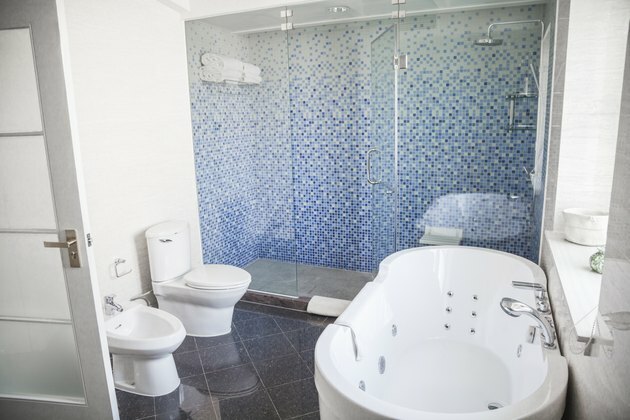 Banheiro moderno e limpo, com vaso sanitário, pia, chuveiro e banheira.