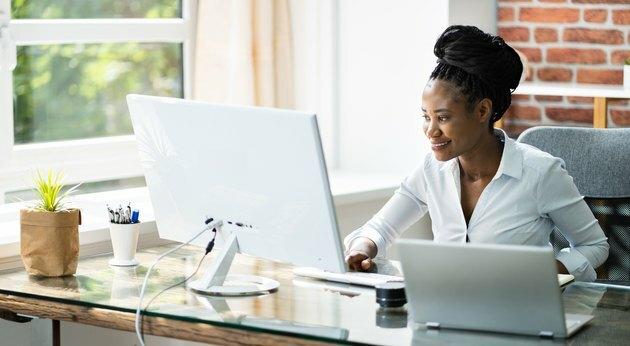 Gelukkig professionele vrouw werknemer met behulp van Computer