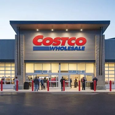 „Costco“ sandėlio išorė, kurioje žmonės stovi lauke.