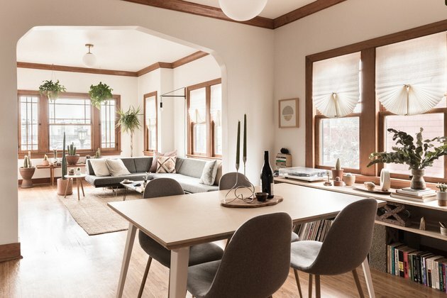 minimalistická jedáleň s dreveným stolom, závesnou lampou a šedými stoličkami Eames