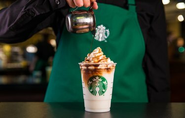 Dipendente di Starbucks che versa il cioccolato sulla bevanda in tazza