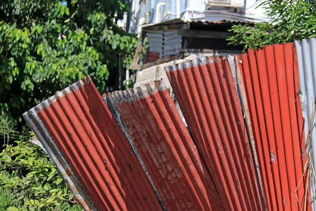 Стари гофрирани ламаринени листове, използвани като ограда в развиваща се страна