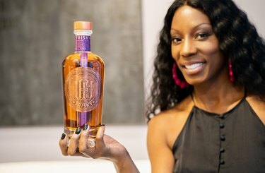 Nicole Young che tiene una vivace bottiglia di whisky