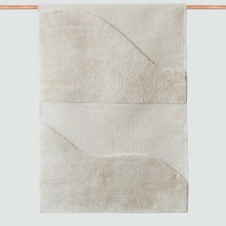 Tapete ecológico branco com design curvo pendurado em haste de cobre