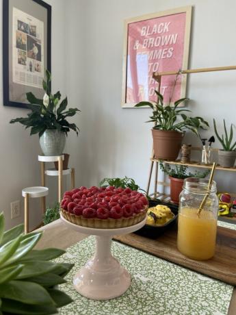 torta em carrinho com decoração e plantas no fundo