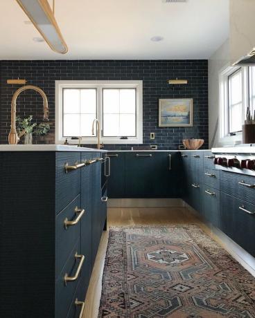 خزائن المطبخ الداكنة مع أرضيات خفيفة مع بلاط باكسبلاش أزرق اللون وأرضيات خشبية فاتحة