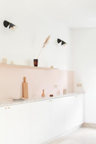 Cucina in stile contemporaneo con alzatina rosa e luci geometriche