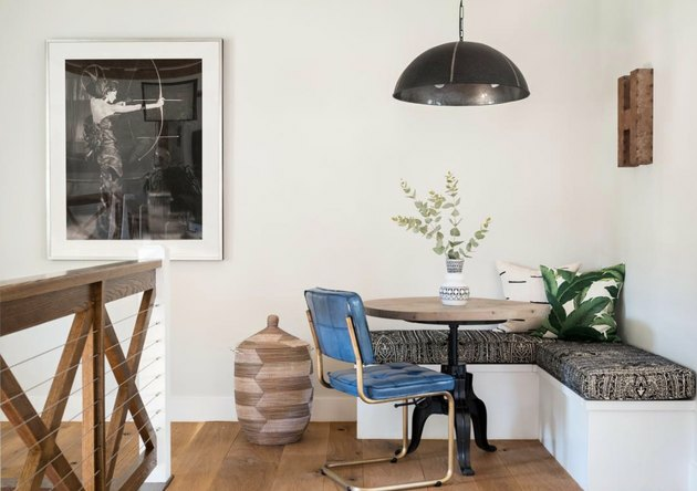 Keukenhoekidee met blauwe vinyl stoel aan een kleine ronde tafel in een moderne eethoek