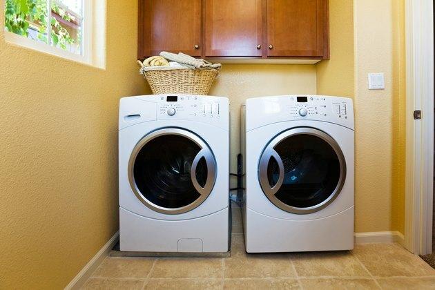 Lavadora e secadora moderna branca na lavanderia da casa.