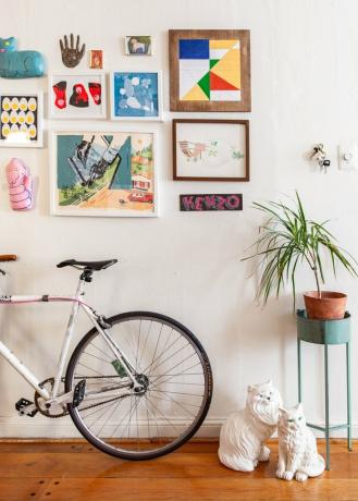 Ideias para paredes da galeria do corredor com bicicleta encostada na parede do corredor com obras de arte