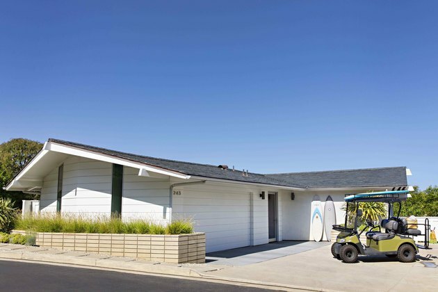 porta de garagem branca em casa estilo fazenda com carrinho de golfe na frente