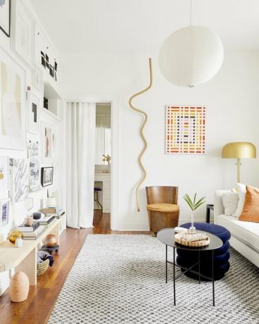 Apartamento contemporâneo com arte na parede vertical dourada e parede da galeria