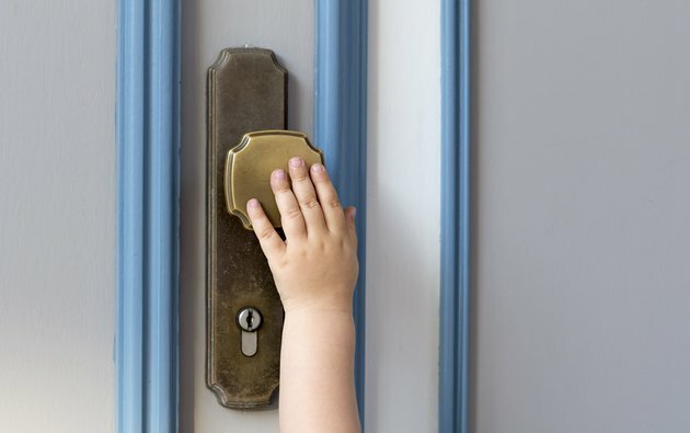 Petit enfant main sur la poignée de porte