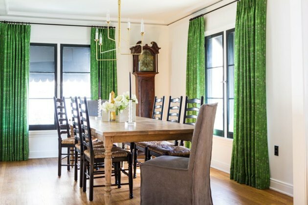 نوافذ سوداء في غرفة الطعام مع أرضيات خشبية وعلاجات النوافذ الخضراء