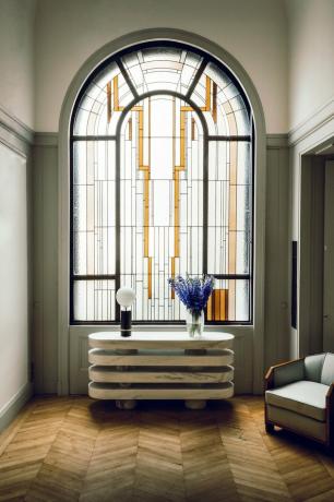 vitral arqueado art deco em frente à mesa de console moderna