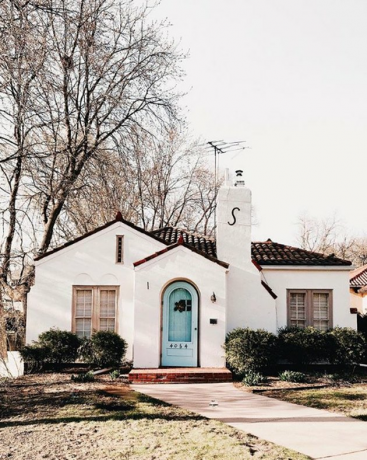 witte traditionele stucwerk huizen met felblauwe deur en Spaans dak