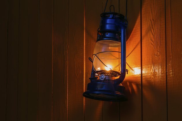 stara latarnia nafty wisząca na żółtej drewnianej ścianie