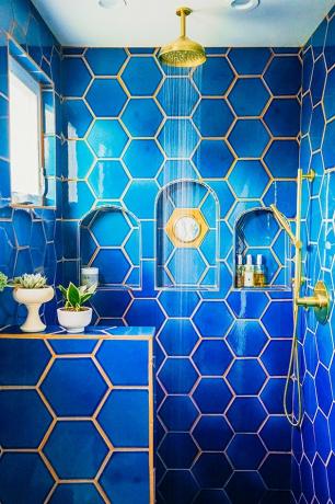 Chuveiro azul em formato hexagonal em banheiro boêmio