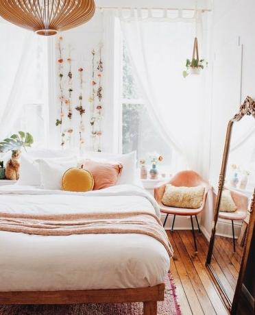 slaapkamer met perzik accenten en bloemen aan de muur