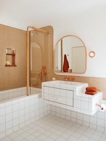 Banheiro projetado por Home Studios NYC com torneira e chuveiro de cobre