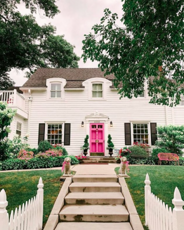 Traditionele witte exterieur huiskleuren met roze deur