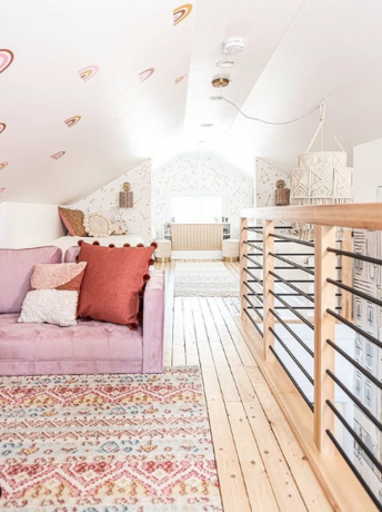 boho zolder woonkamer met houten vloeren, vloerkleden en geweven accessoires