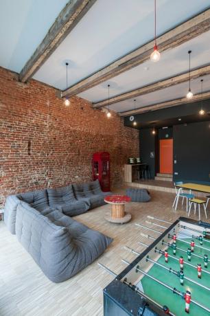 ideias de sala de jogos para garagem industrial com sofá e matraquilhos