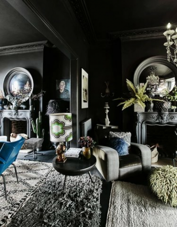 sort stue med højt til loftet og store runde spejle