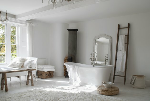 Armazenamento do banheiro da fazenda projetado por White & Faded com cestas e banheira