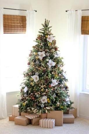 kerstboom aan de kust met gigantische faux magnolia, glazen bollen en gouddraad