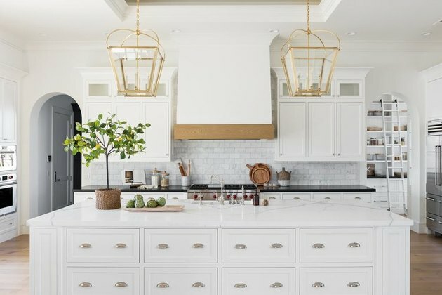 keukeneiland decor in witte keuken met metro tegel backsplash en houten vloer